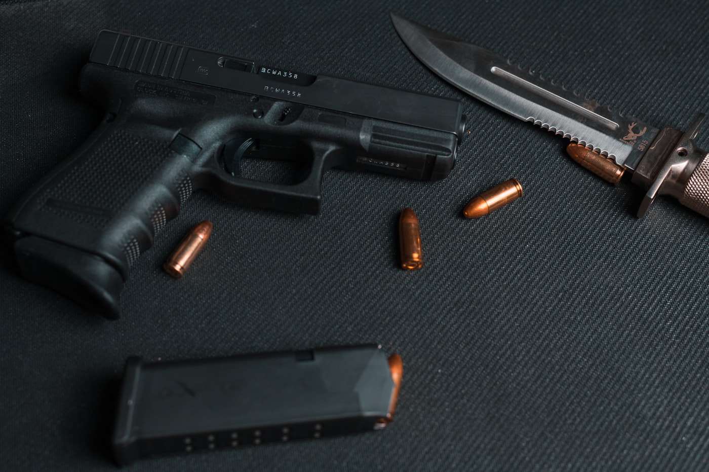 Pistol and brass on a dark surface